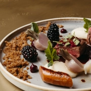 Nachaufnahme eines Tellers mit kleinen Radieschen, Brombeere, Fleisch, chic angerichtet