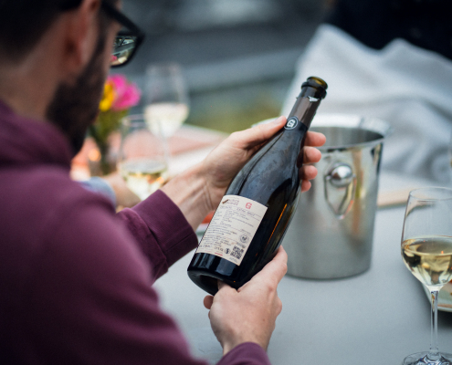 Ein Gast schaut sich eine Champagnerflasche an