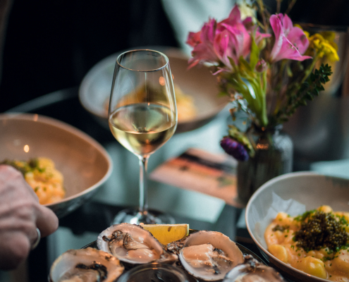 Stilvolles Foto von einem Champagnerglas und Austern auf einem Glastisch
