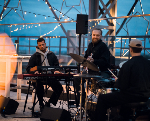Eine Band spielt bei Dämmerung auf dem Gasometer SKY